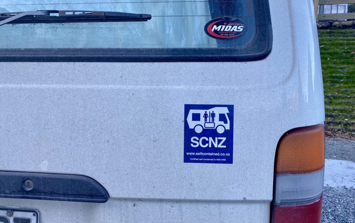 A Self-Contained sticker in New Zealand on the back of a converted campervan.