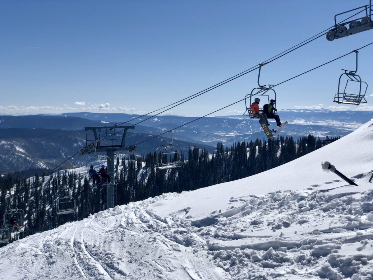 A ski lift in Colorado, with snow and mountain scenery.