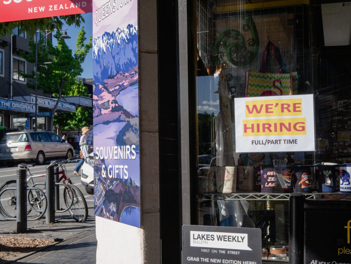 A gift shop window with a "hiring" sign in Queenstown, NZ