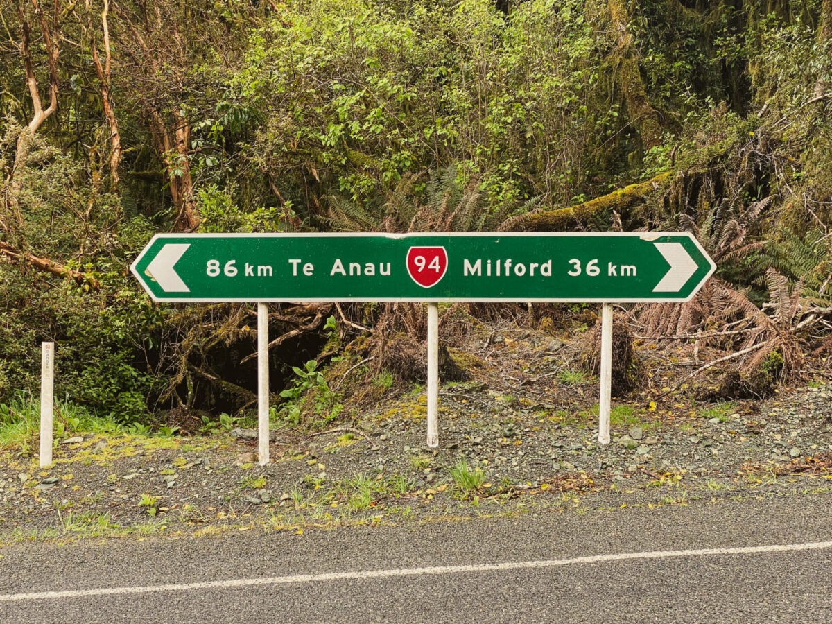 A road sign in Fiordland National Park depicting the distance to Te Anau and Milford Sound.