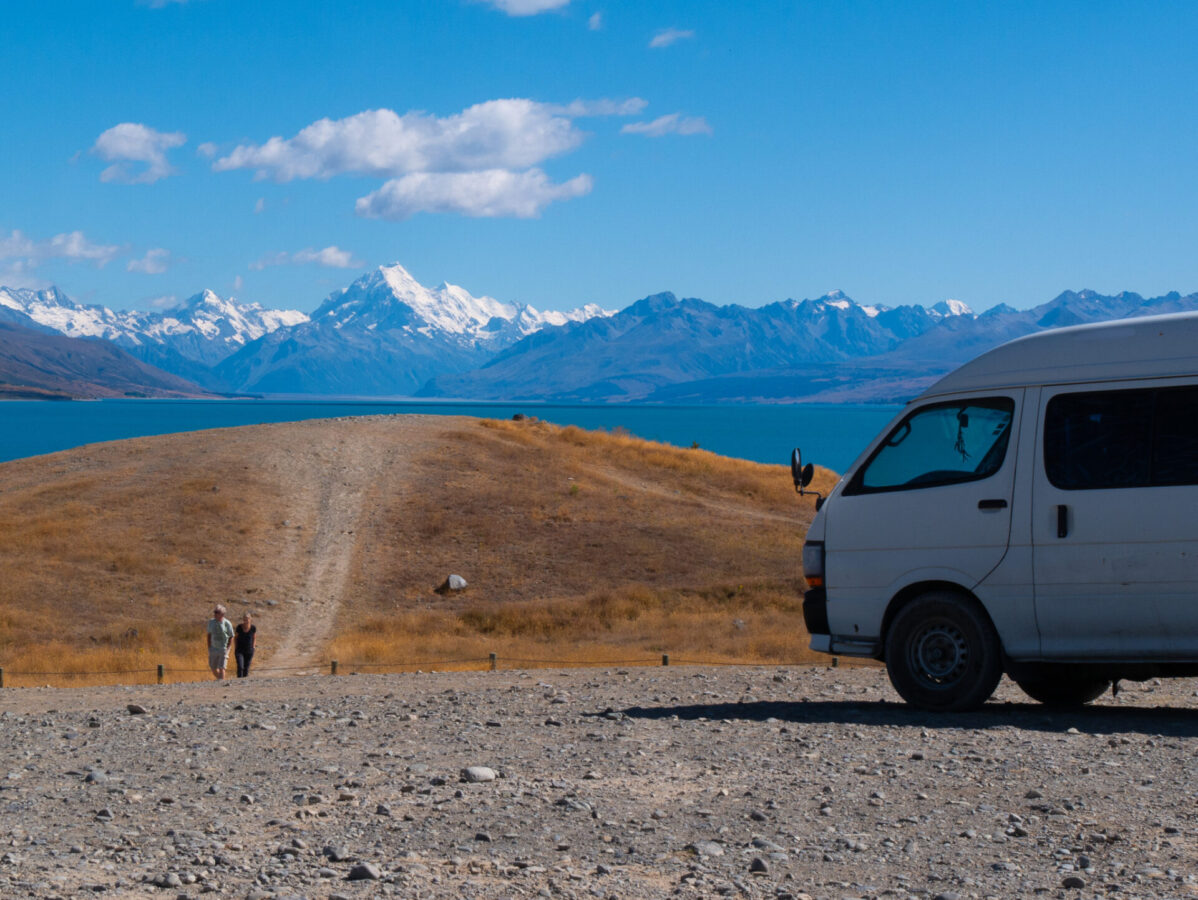 A van parked in front of the scenic Mt. Cook in New Zealand.