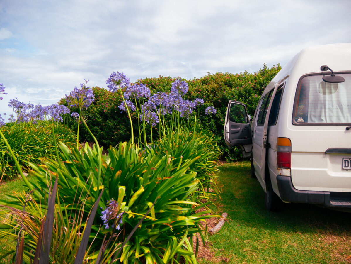 A converted campervan parked at a campground on the west coast of New Zealand's South Island.