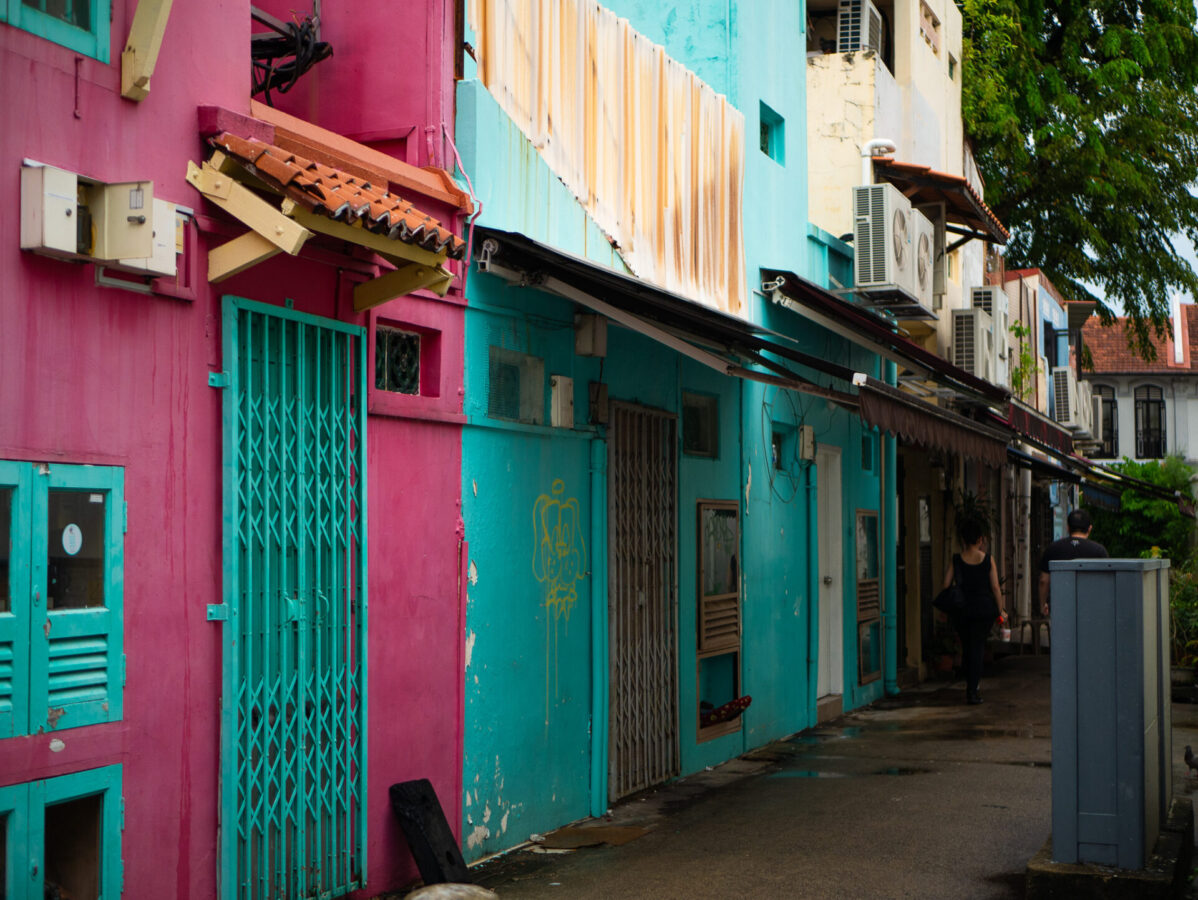 Pink and blue buildings on a side street in Singapore.